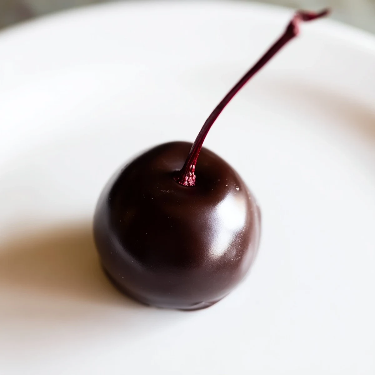 A close-up view of chocolate covered cherries on parchment paper, ready for gifting or satisfying a sweet craving.