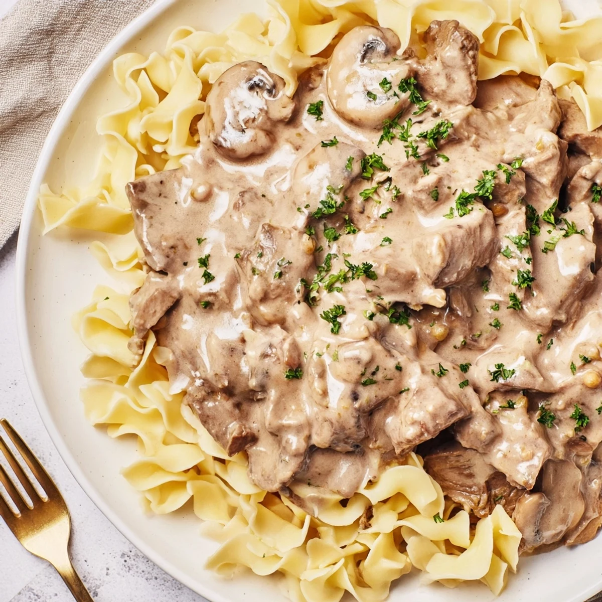 Golden-brown beef strips and sautéed mushrooms swim in a creamy sauce piled high over buttery egg noodles for Beef Stroganoff.  