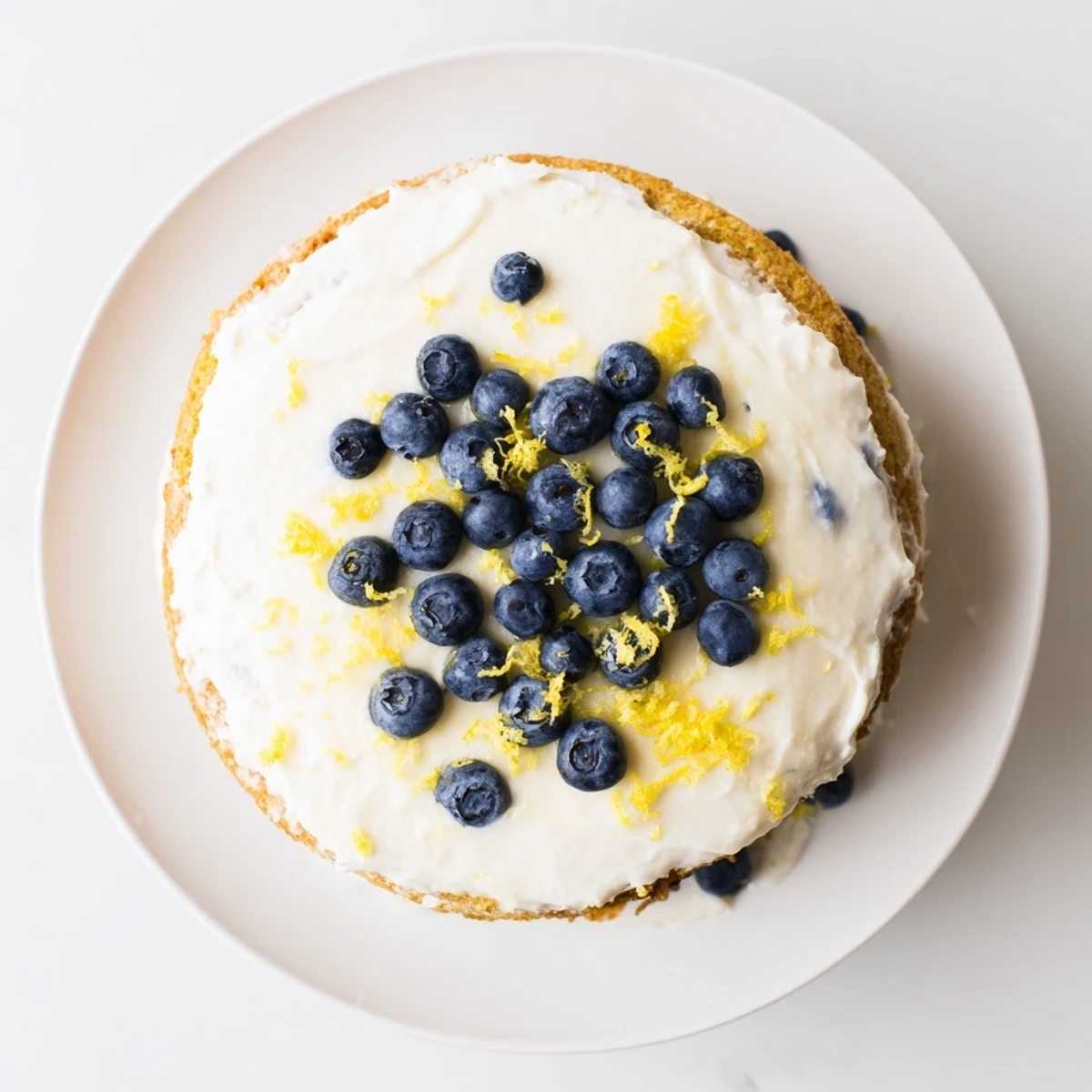 Layered Lemon Blueberry Cake with cream cheese frosting, featuring golden cake crumb and fresh blueberries, ready for a springtime dessert table.
