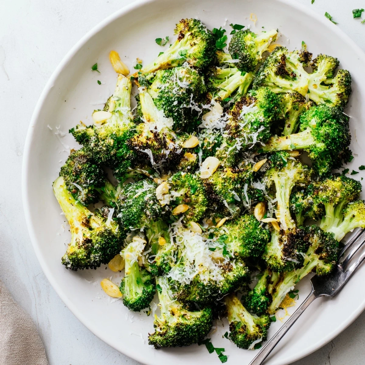 Tender-crisp Roasted Broccoli with Garlic and Parmesan garnished with fresh parsley, ready to pair with grilled chicken.