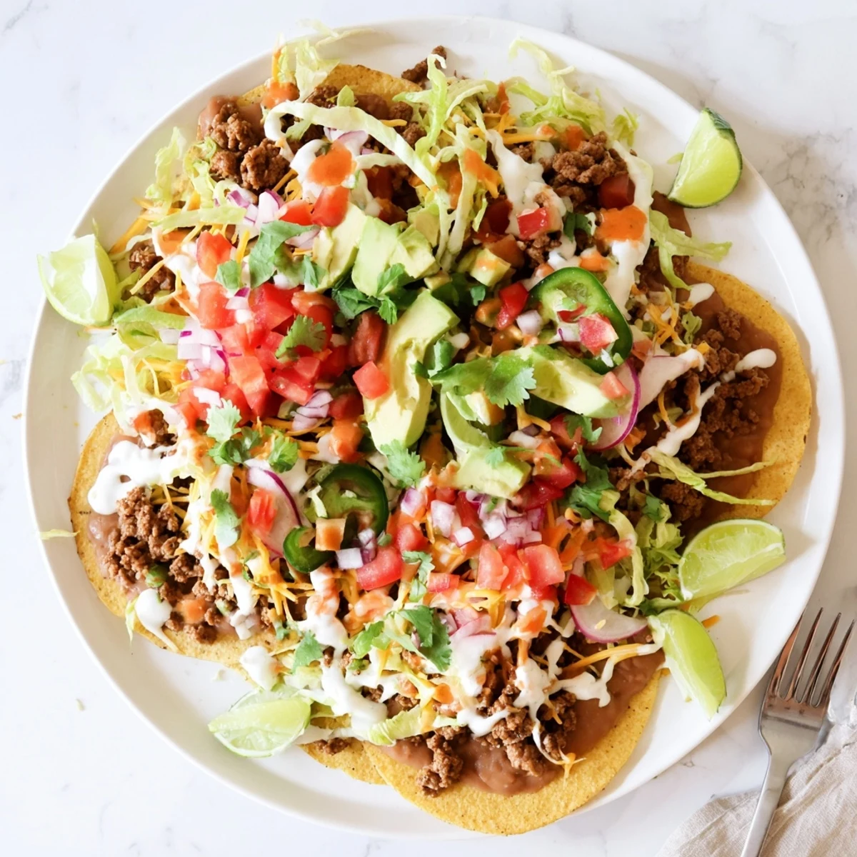 Crispy corn tostadas loaded with savory seasoned ground beef, creamy refried beans, and fresh lettuce.