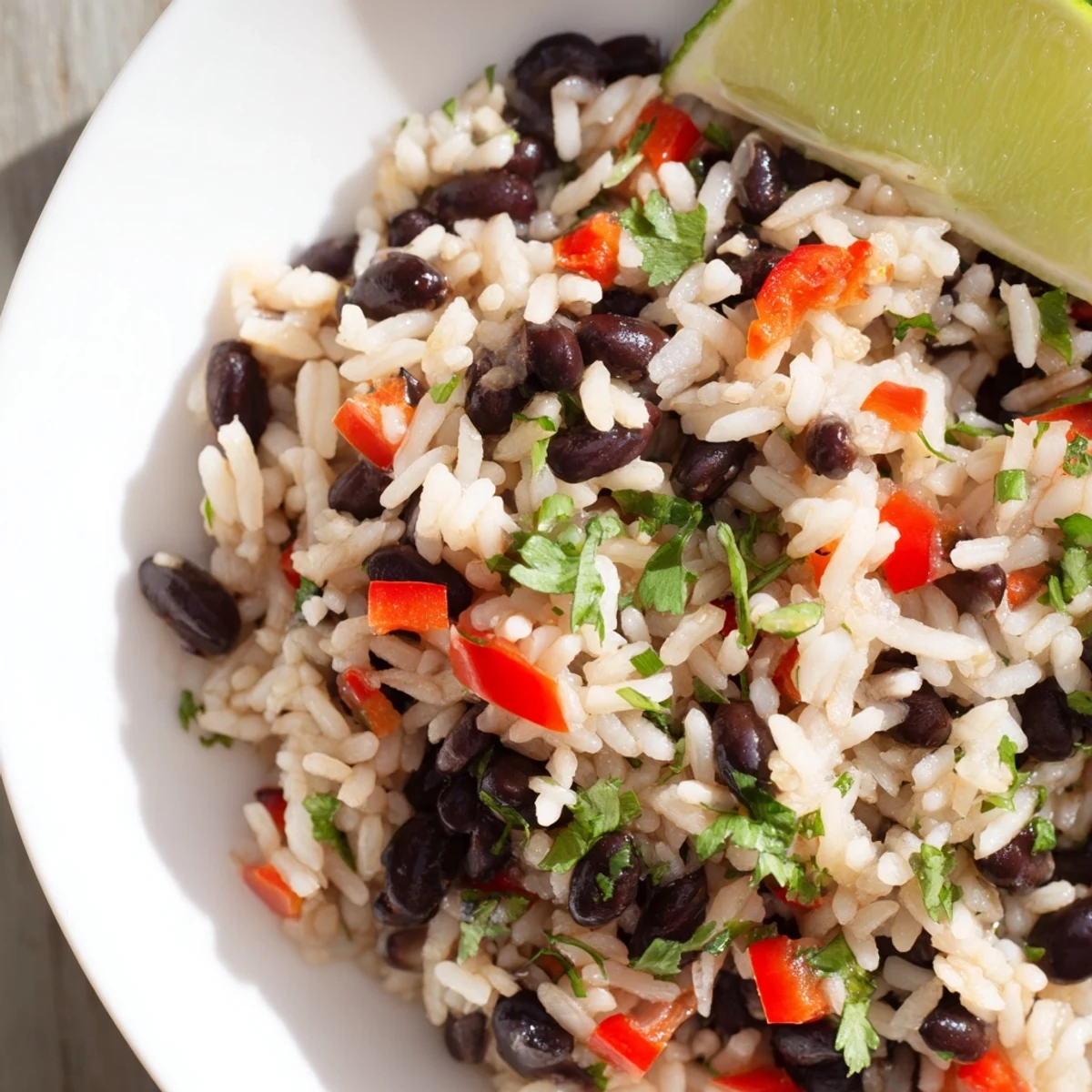 A vibrant serving of Rice and Beans with Spices in a rustic bowl, topped with cilantro and lime.