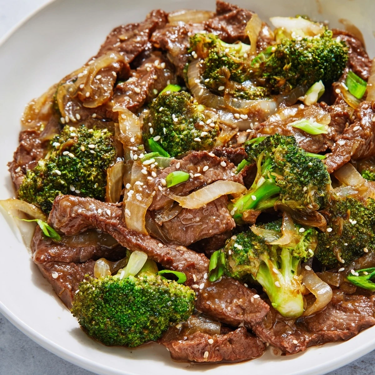 Steamed jasmine rice sits beside Beef and Broccoli Stir Fry with Garlic Sauce, featuring glossy, tender beef slices and crisp, bright green broccoli florets.