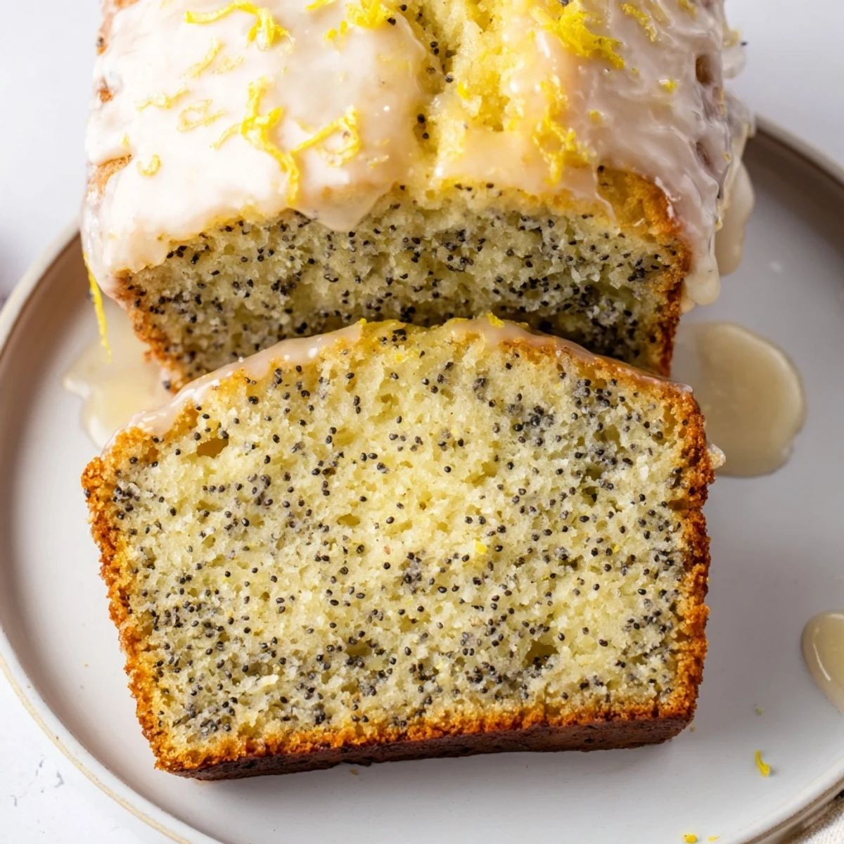 A freshly baked Lemon Poppy Seed Loaf glazed with lemon icing on a wooden board.