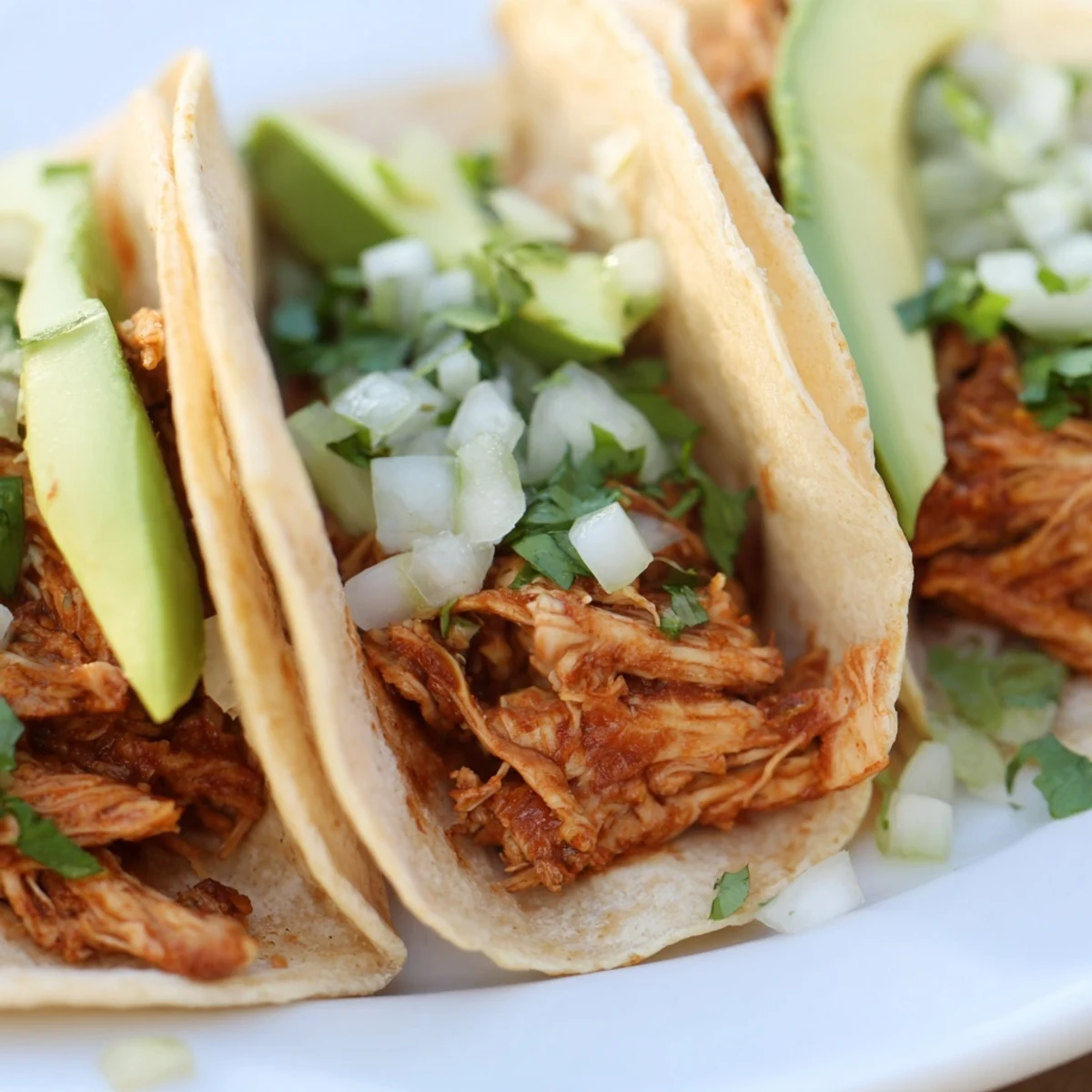 Tender grilled chicken thighs and avocado slices on soft tortillas, creating a vibrant platter of Chicken Street Tacos.