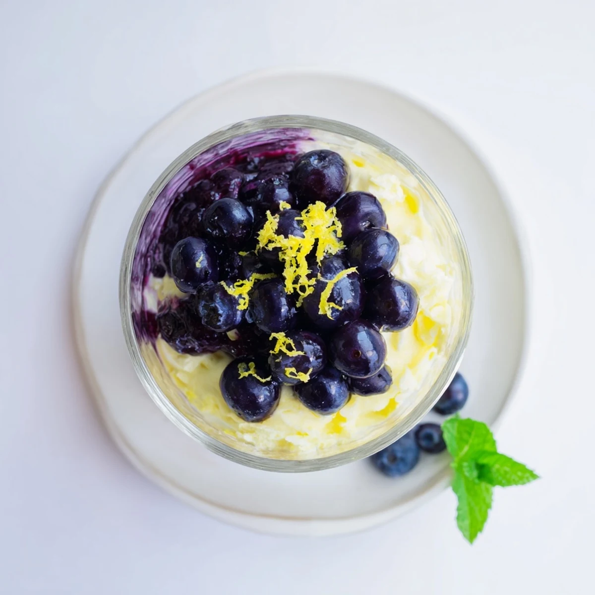 Close-up on fresh blueberries and mint atop a serving of Lemon Blueberry Mousse.