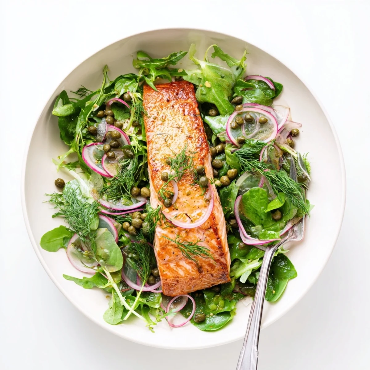 Golden-brown crispy skin Tasmanian Atlantic salmon fillet resting beside a bright lemony herb salad with fresh dill and red onion.
