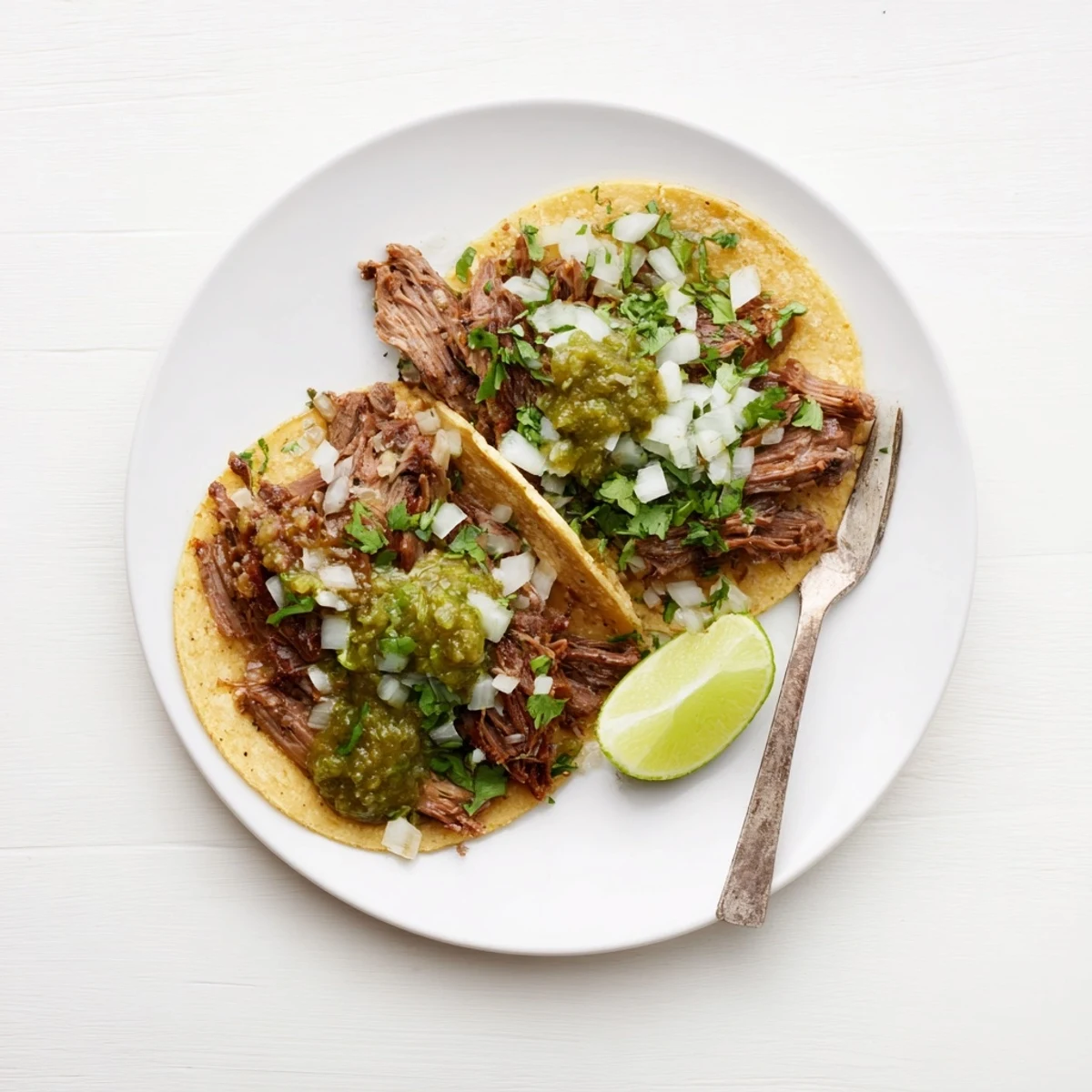 A plate of gluten-free beef cheek tacos featuring juicy shredded meat, fresh toppings, and vibrant salsa ready to be enjoyed.