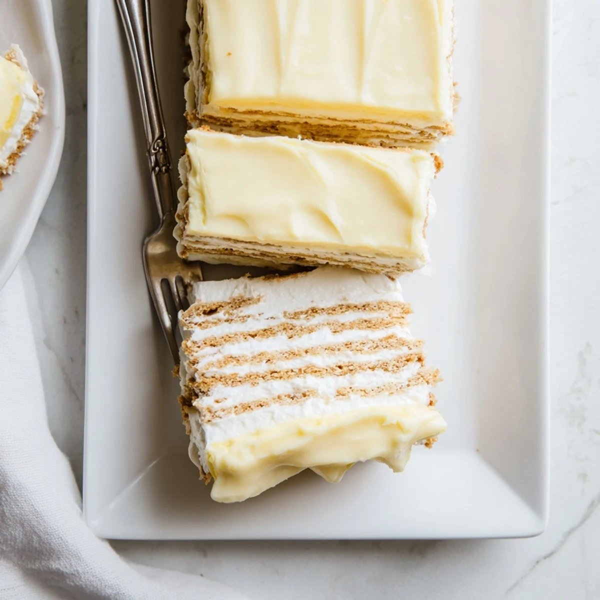 Lemon glazed no bake eclair cake with whipped cream and zesty pudding layers