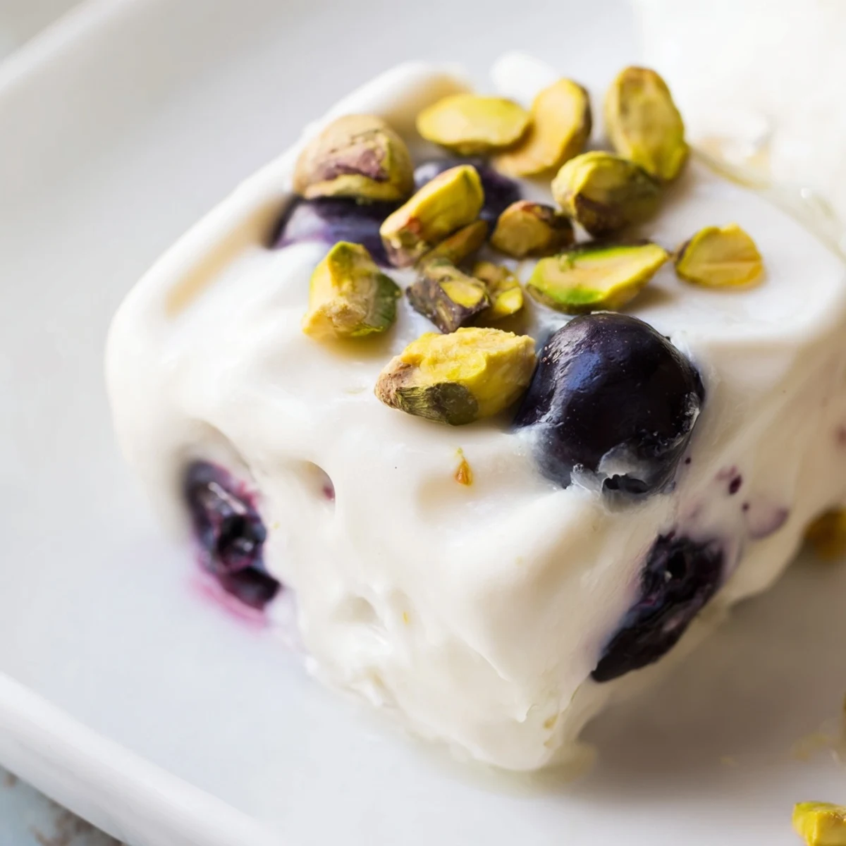 White creamy Greek yogurt mounds studded with blueberries on a baking sheet