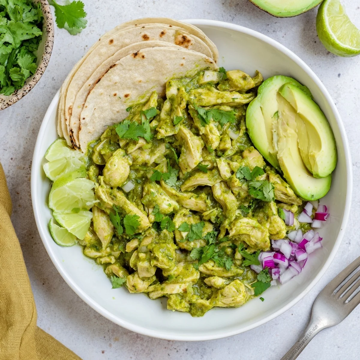 Tender shredded chicken coated in tangy salsa verde for Taco Tuesdays, ready to serve