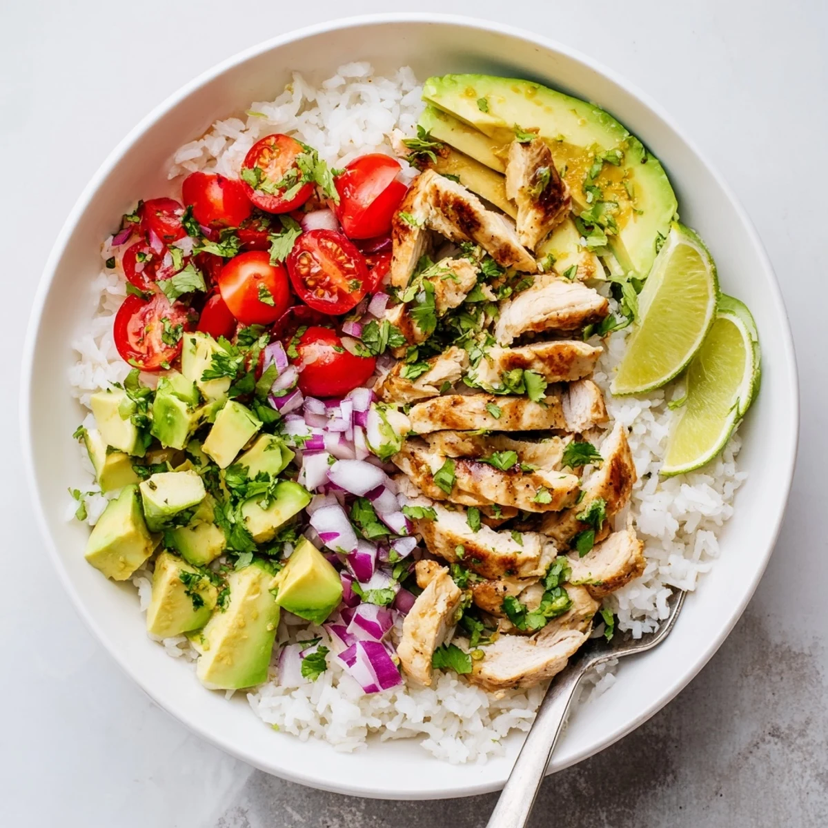 Golden honey lime chicken slices served over fluffy white rice with creamy diced avocado and fresh cilantro garnish