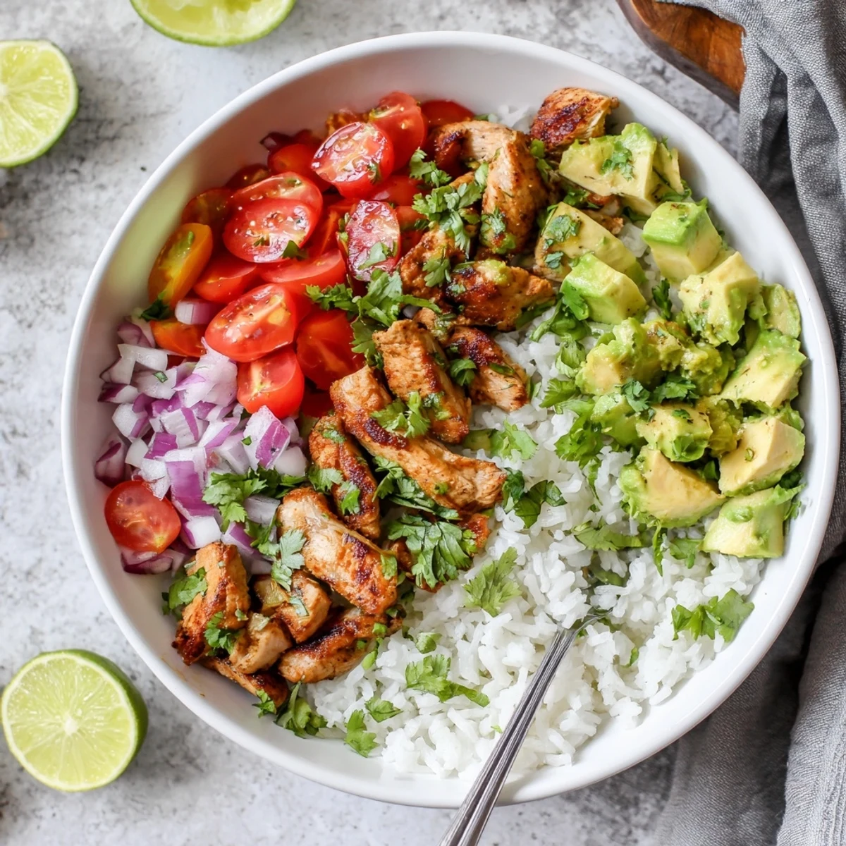 Zesty honey glazed chicken atop steaming rice with buttery avocado pieces lime wedges and chopped fresh herbs