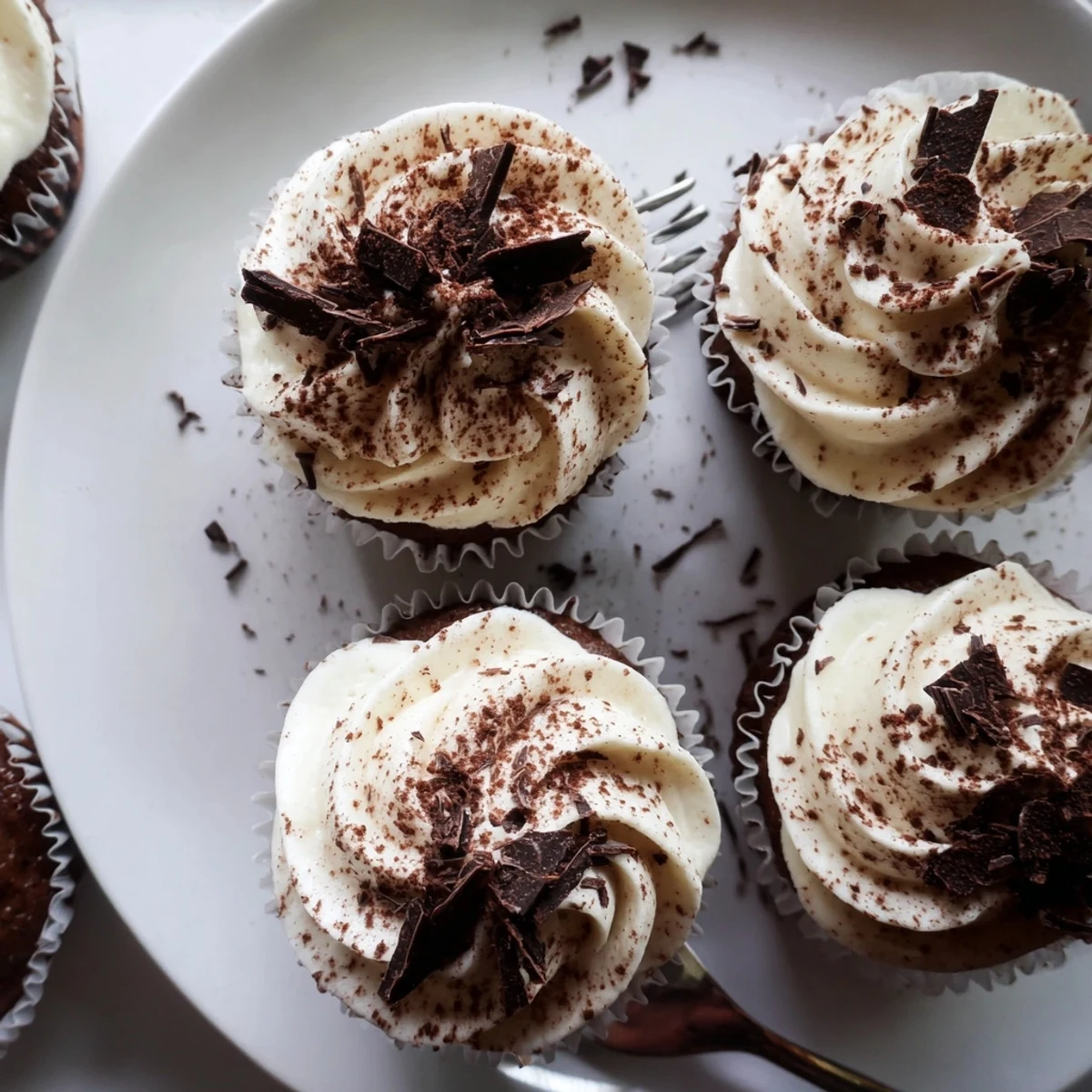 Rich chocolate cupcakes soaked in coffee syrup beneath creamy white mascarpone frosting swirls