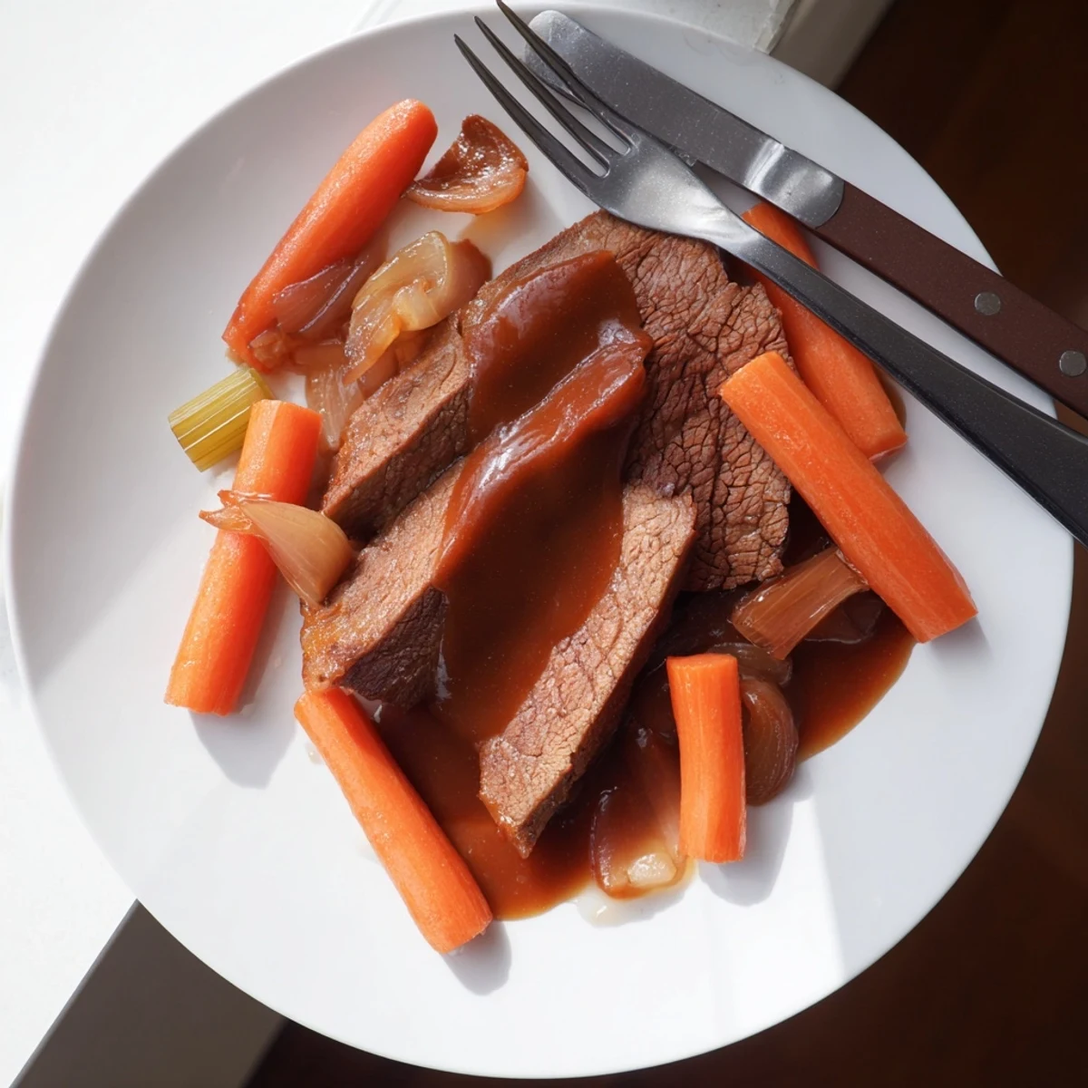 Golden slices of slow cooker beef brisket served with caramelized vegetables and glossy rich sauce