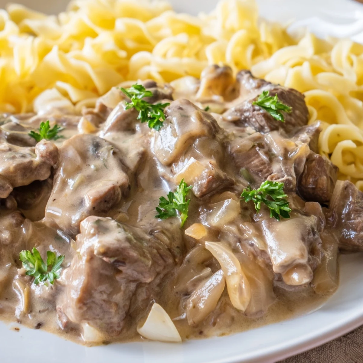 Classic beef stroganoff plated over white rice with golden brown sautéed mushrooms