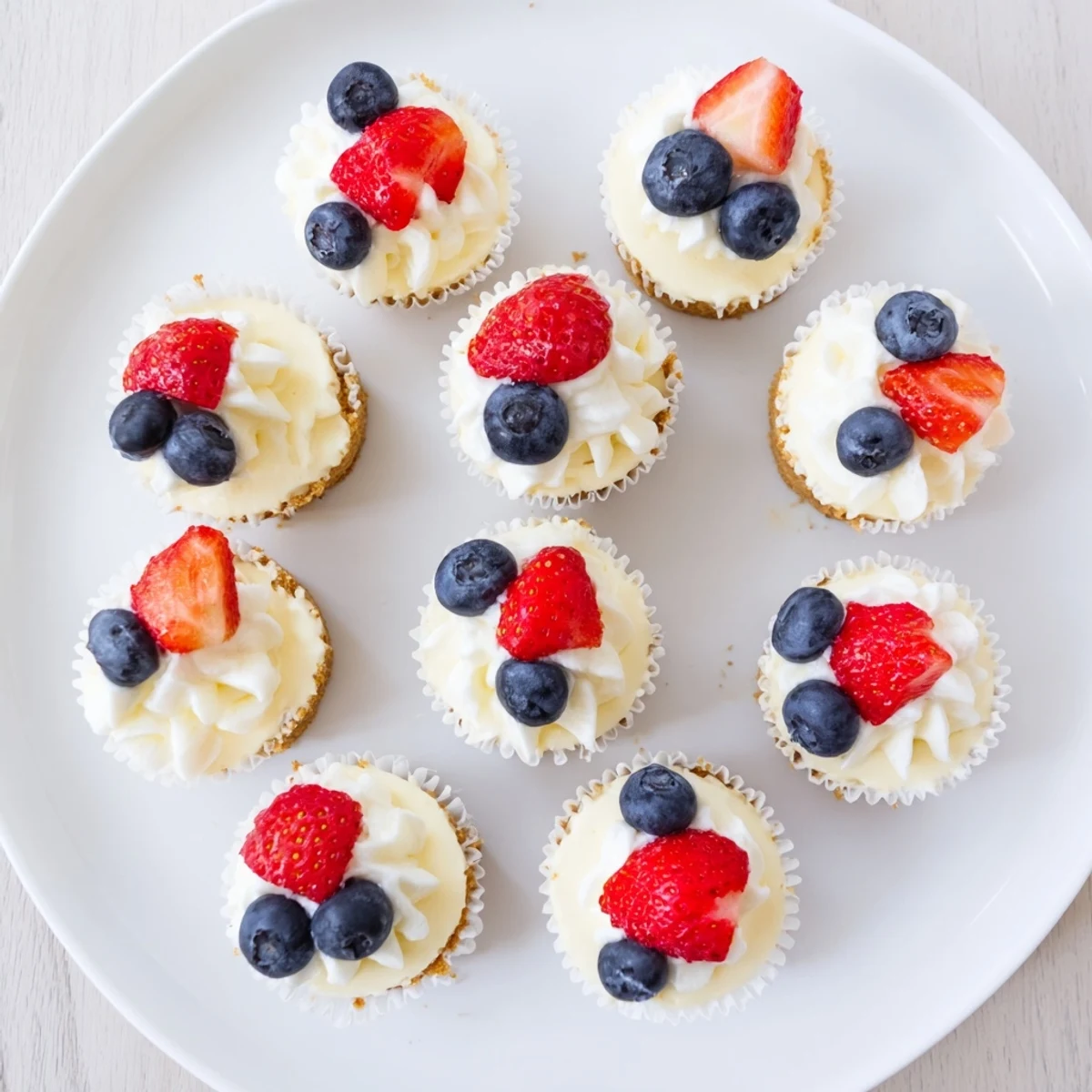 Bite-sized cheesecakes with golden vanilla wafer base garnished with colorful fresh fruit topping