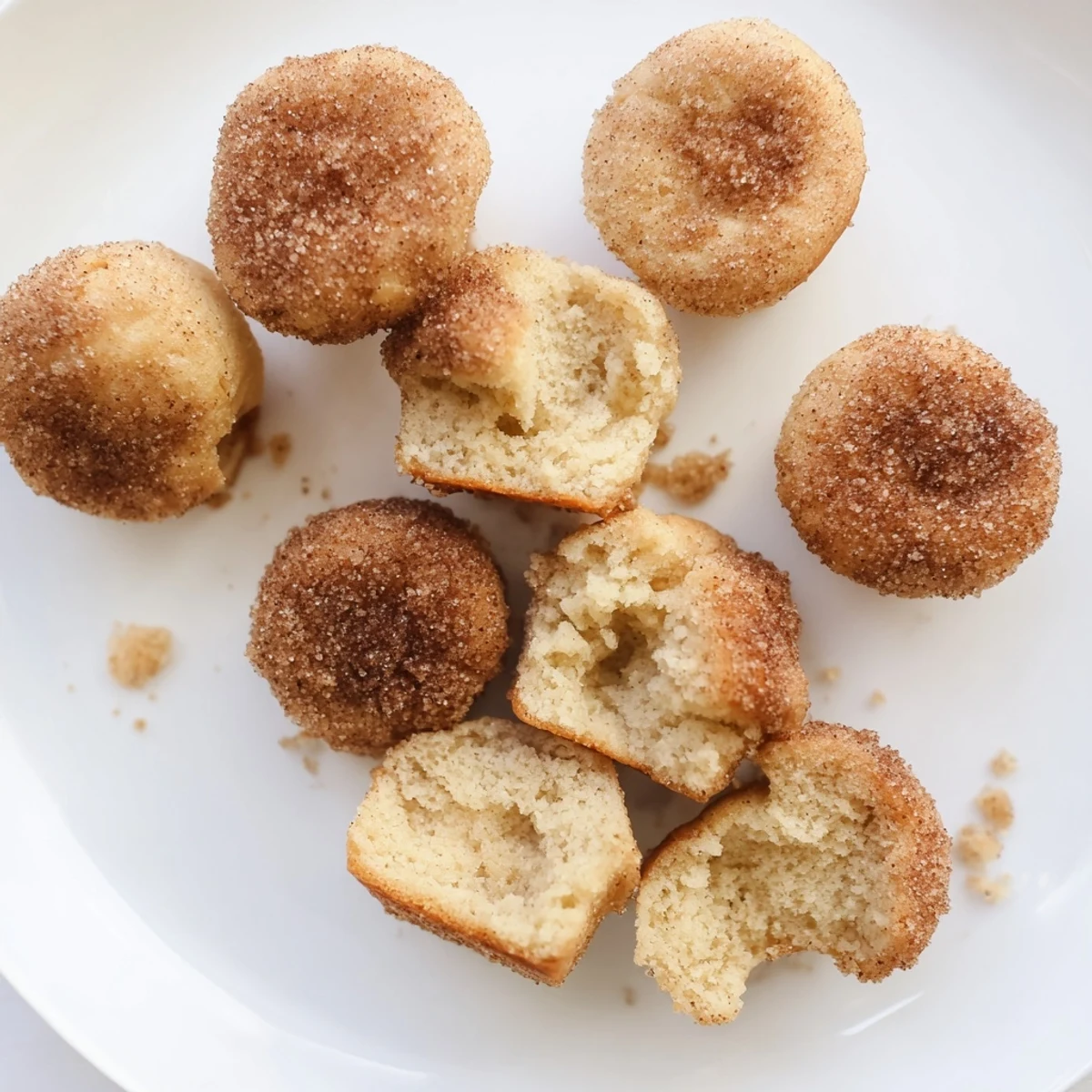 Warm tender mini muffins rolled in cinnamon sugar, ready for breakfast or snacking