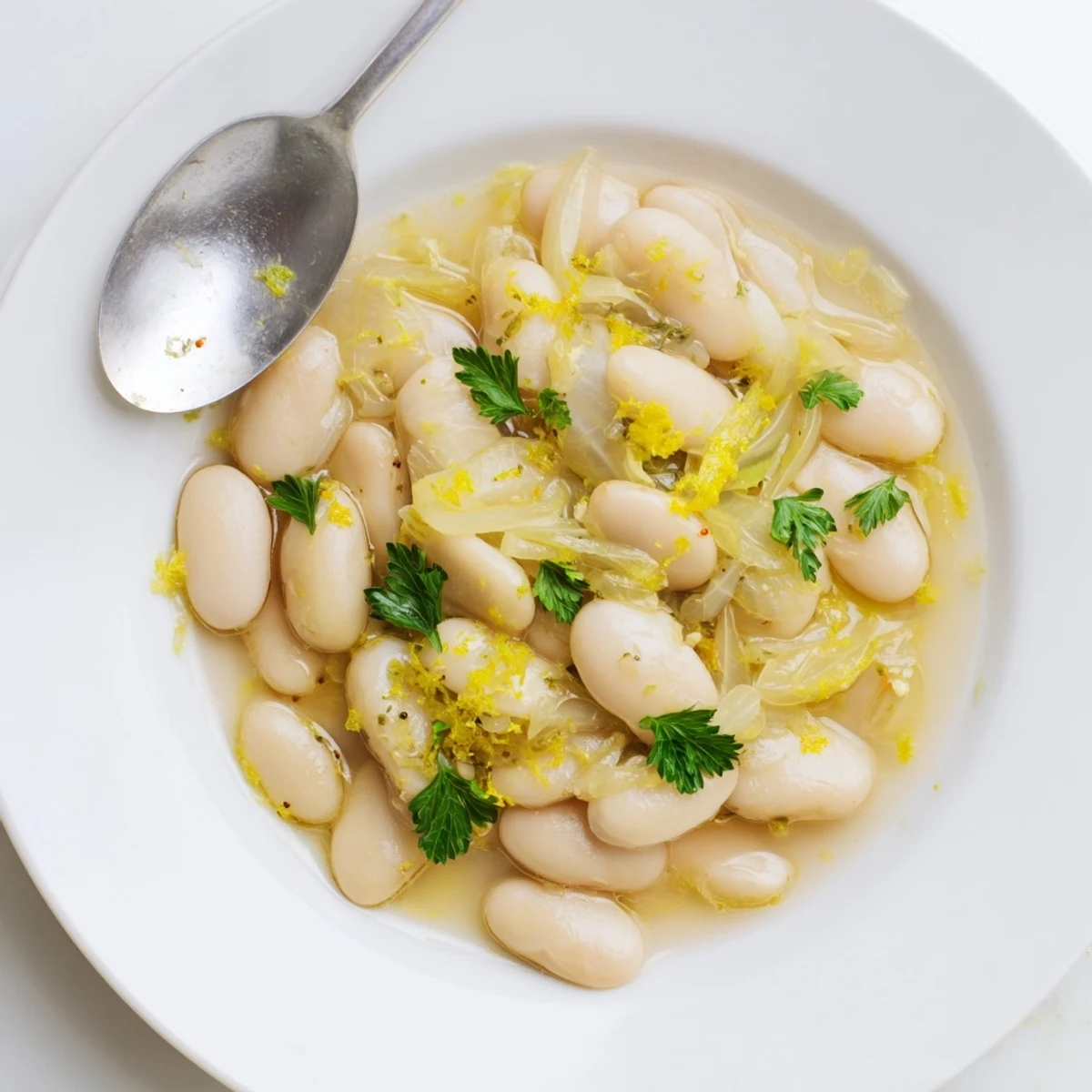 Golden butter beans paired with soft aromatic leeks in a rich vegetable broth sauce