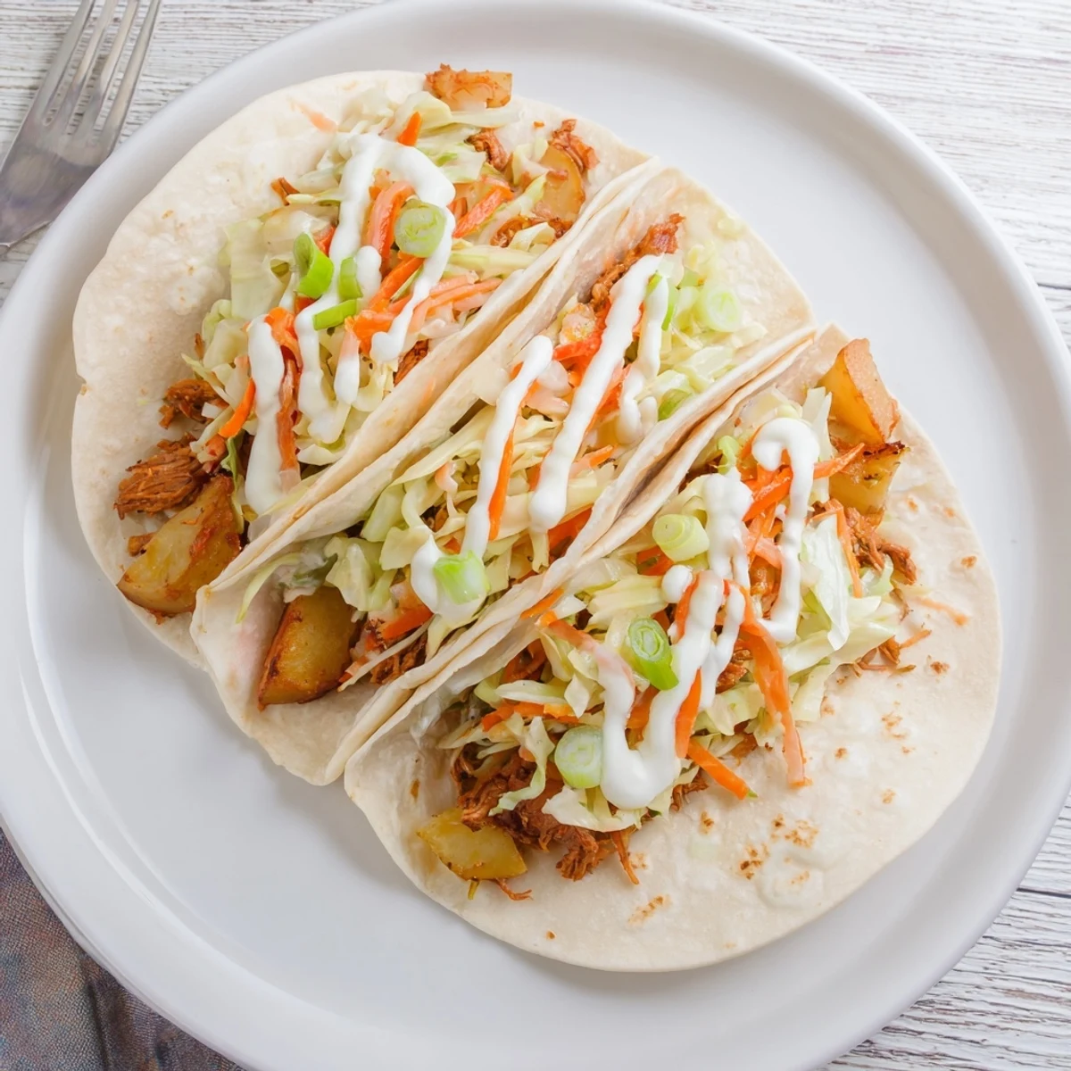 Irish tacos stacked high with shredded beef, crunchy vegetable slaw, and creamy sour cream topping