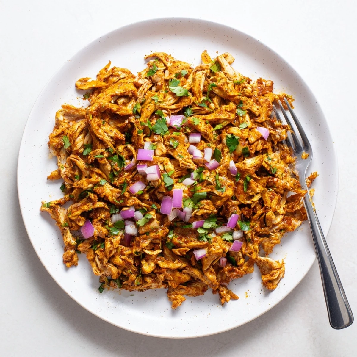 Crispy shredded mushroom carnitas on tacos with diced onion and lime wedges