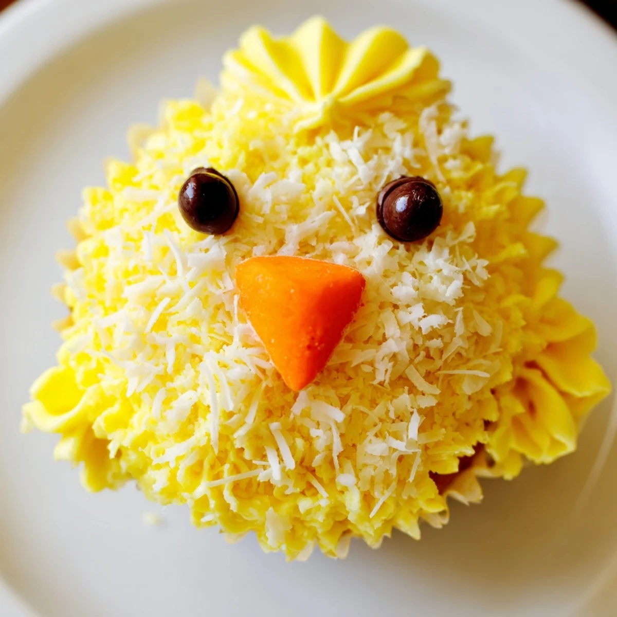 Festive Easter Chick Cupcakes topped with buttercream, coconut feathers, and candy beaks ready for holiday celebrating