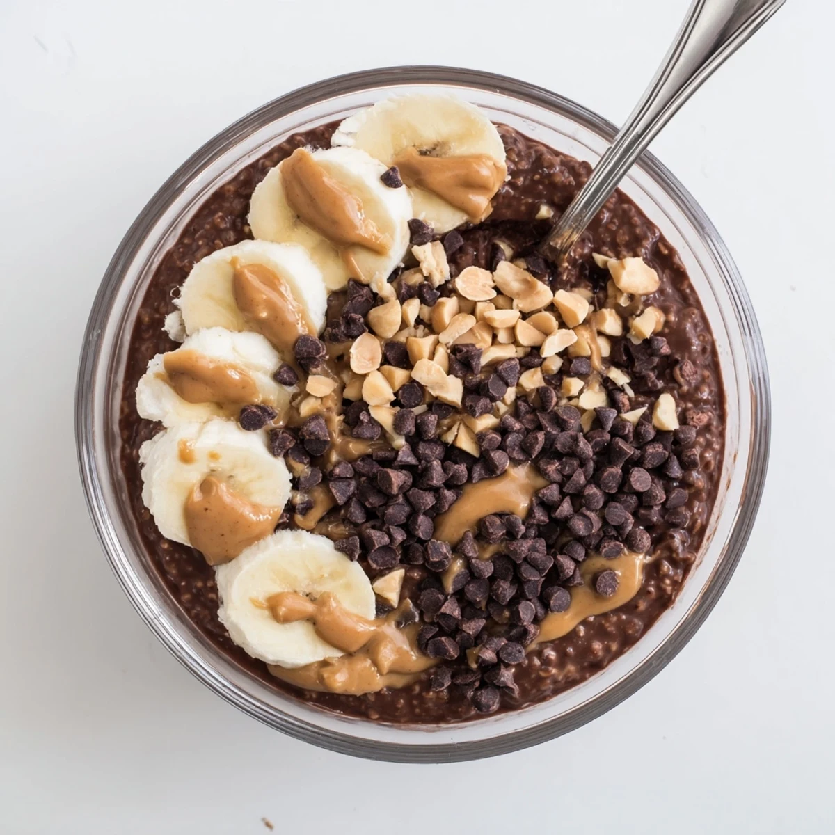 Creamy chocolate peanut butter overnight oats topped with chocolate chips in a glass jar