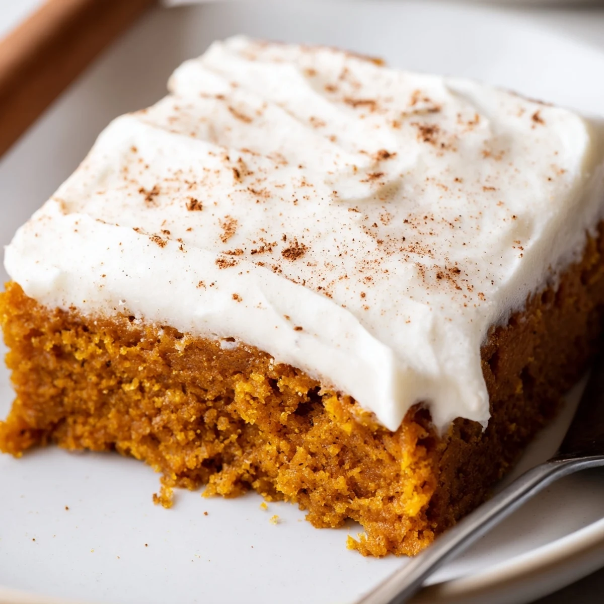 Rich orange pumpkin bars with cream cheese frosting cut into neat bakery-style squares