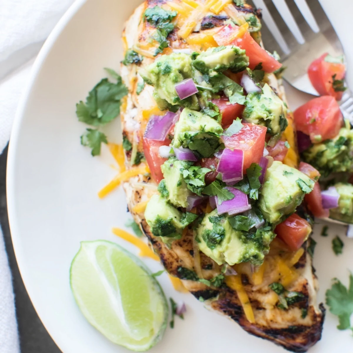 Golden seared fiesta lime chicken served with diced avocado and a lime wedge