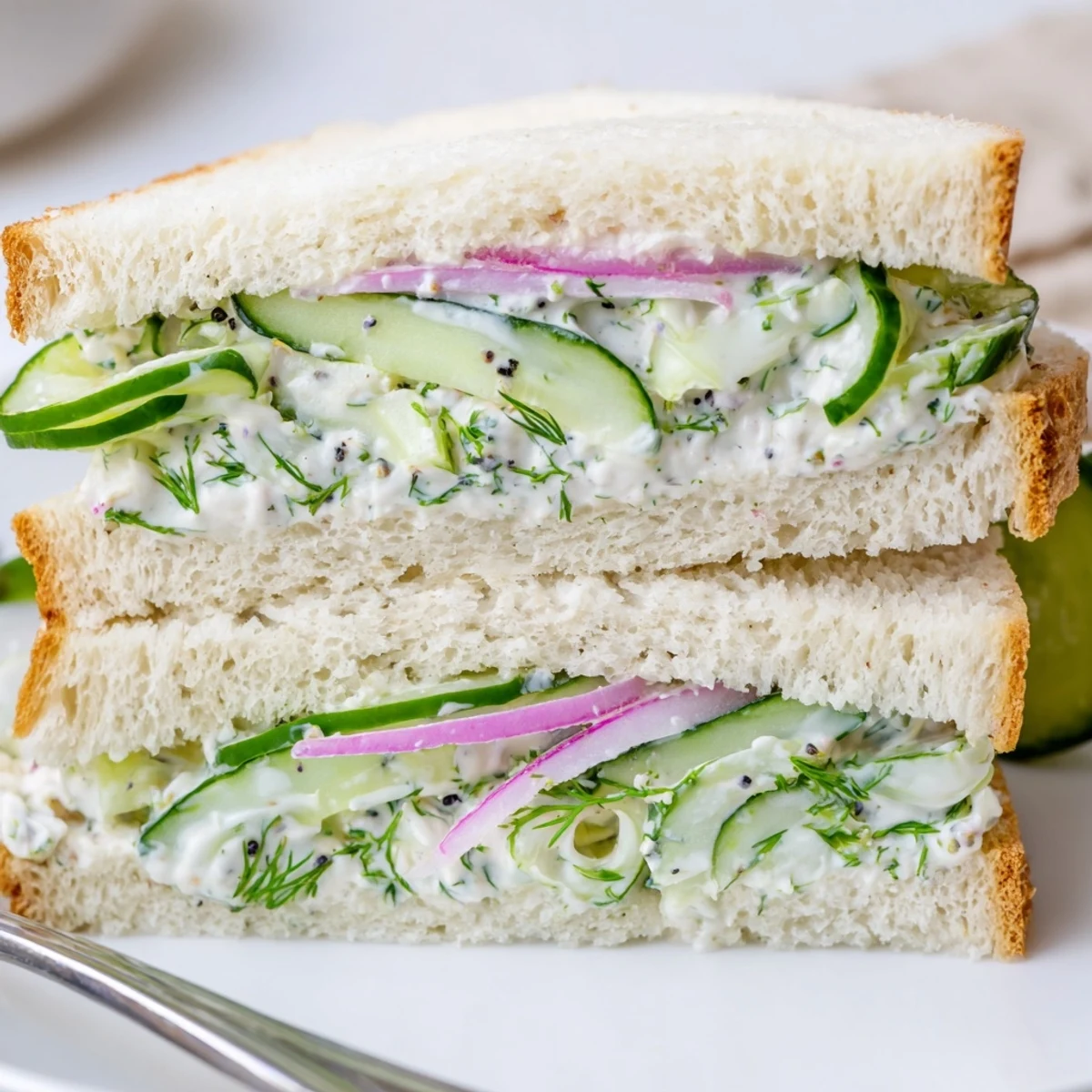 A plate of Quick Cucumber Salad Sandwiches with crisp dill and creaminess