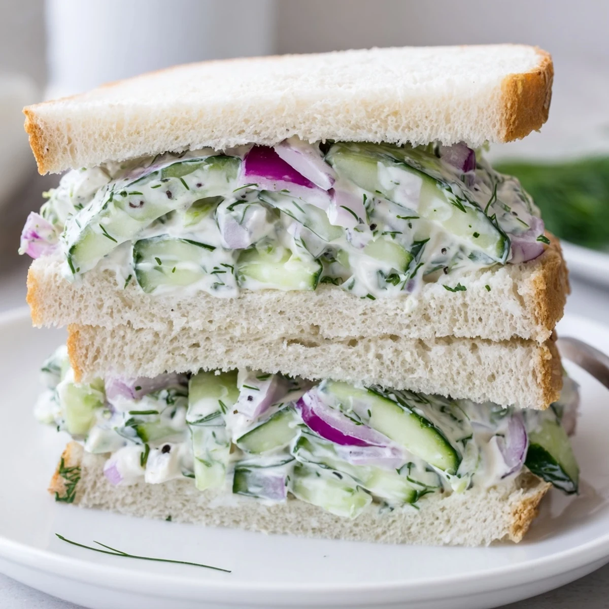 Buttered bread hugging Quick Cucumber Salad Sandwiches, zesty lemon yogurt dressing shines