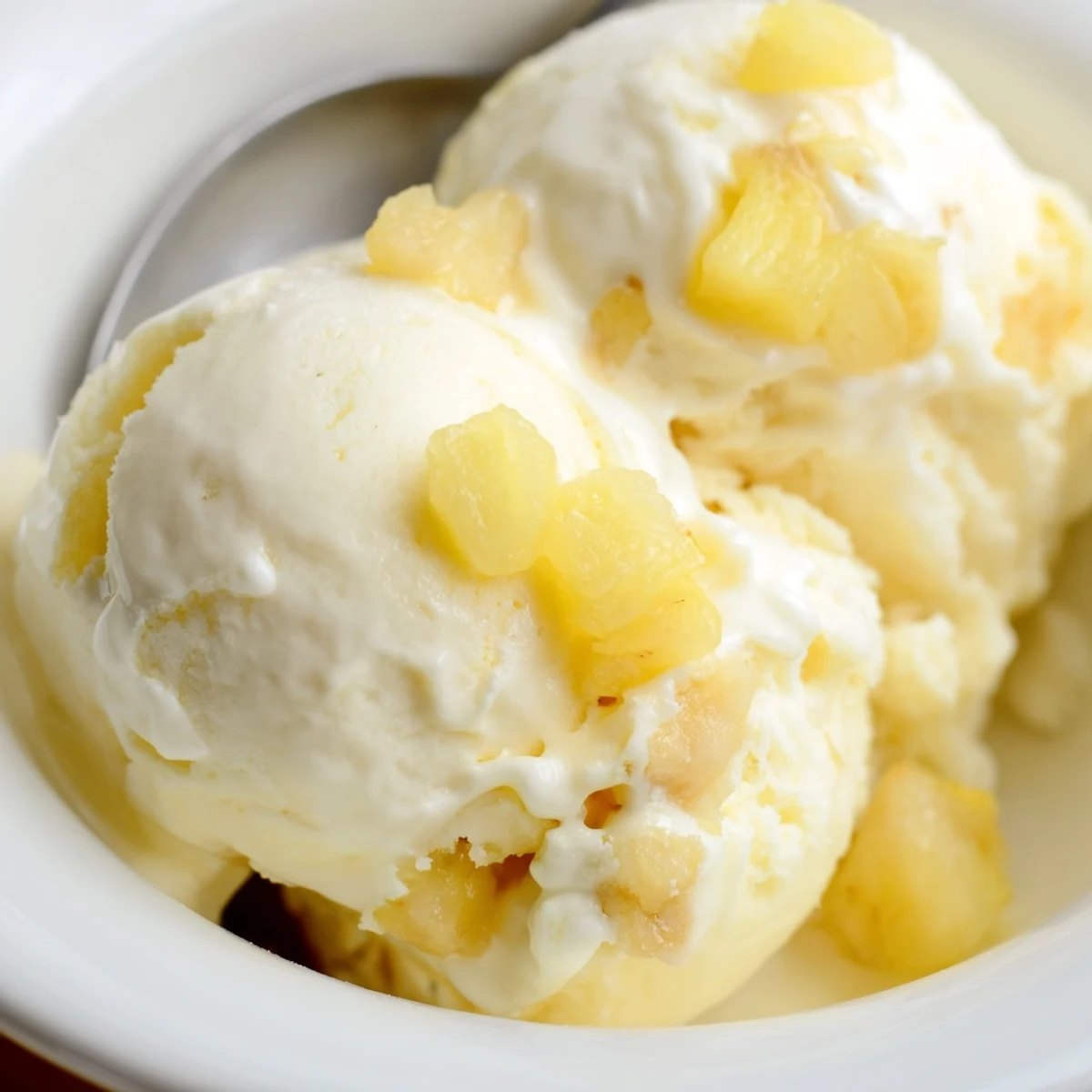 Sunshine-yellow scoops of Creamy Pineapple Ice Cream Recipe, velvety and lightly tangy