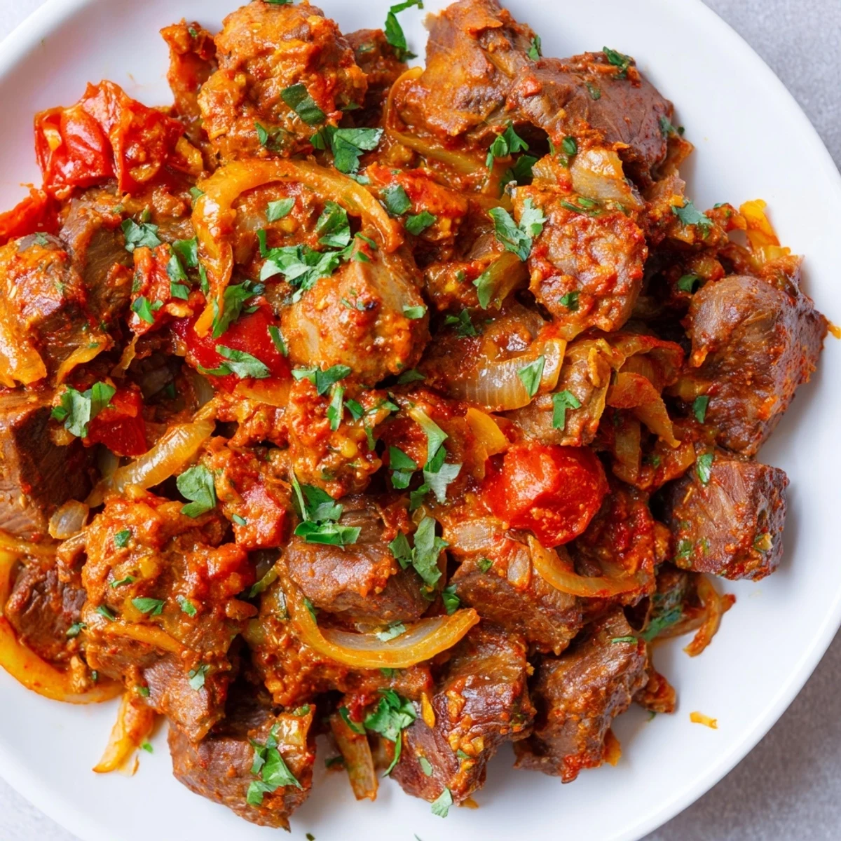 Savory goat meat pieces simmered in aromatic spices served alongside fluffy white rice on a wooden board