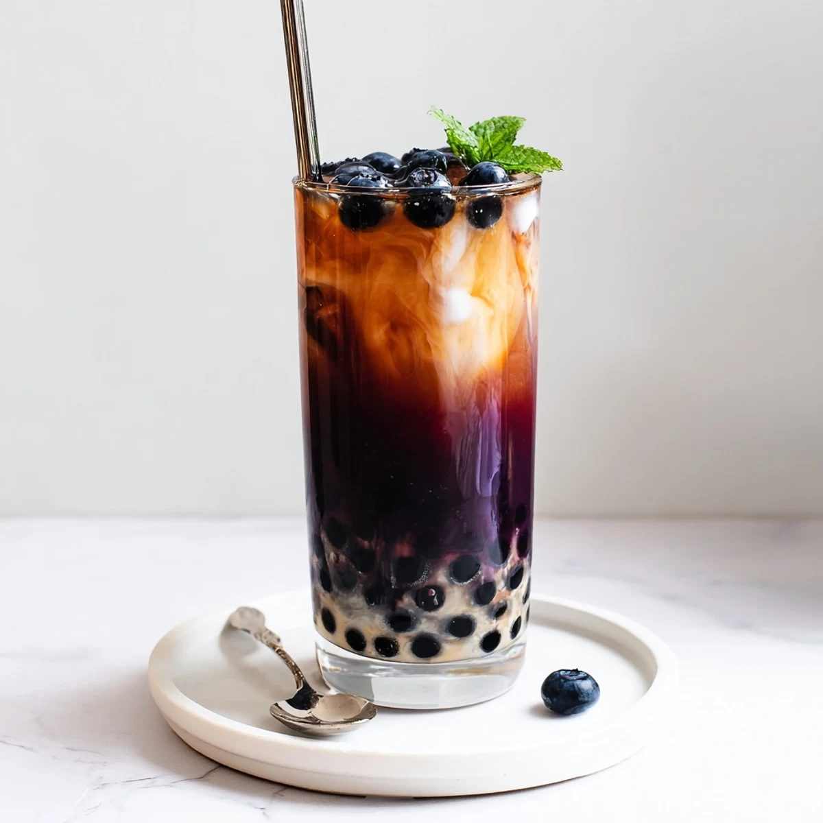 Blueberry Milk Tea Cooler with glossy tapioca pearls, ice, and creamy milk.