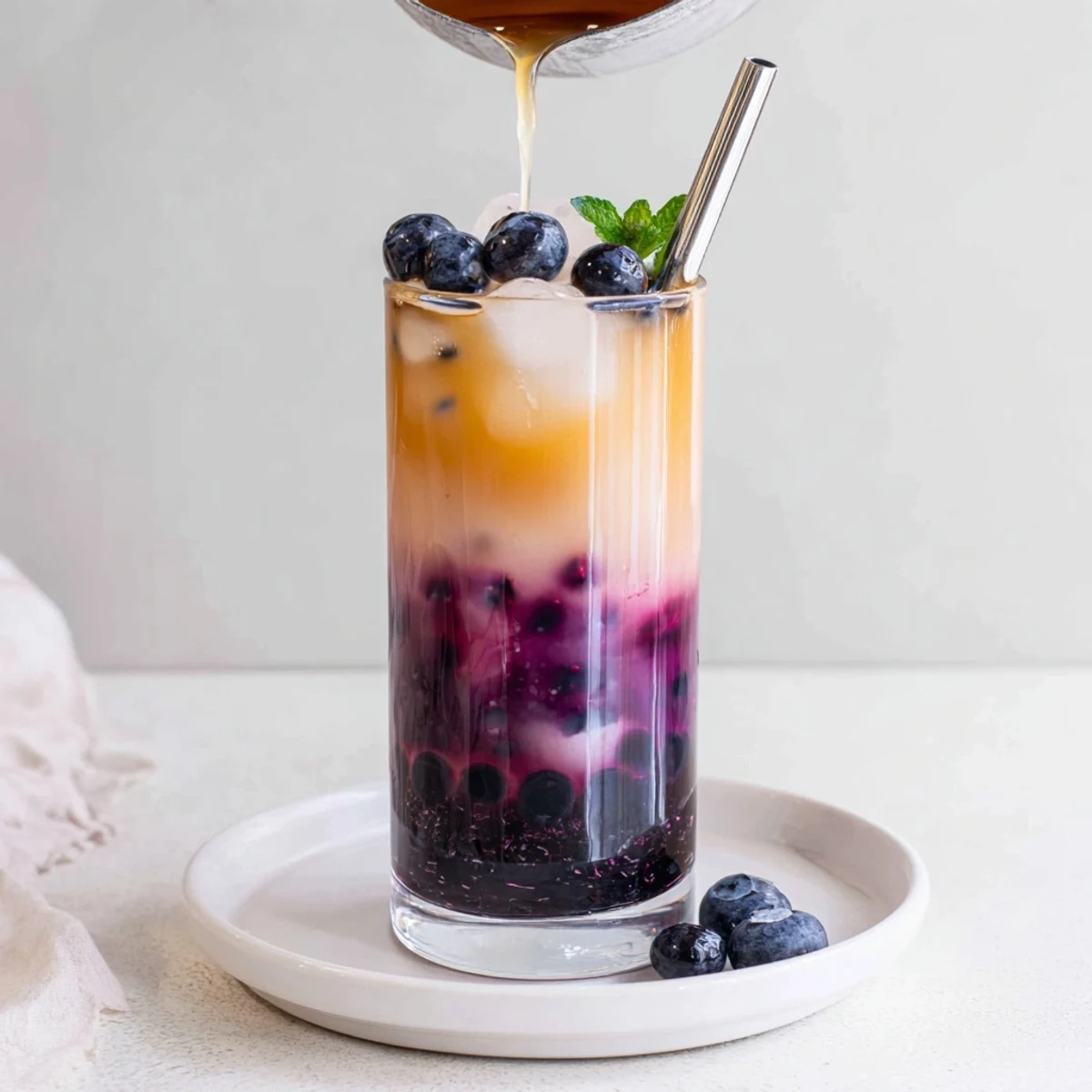 Chilled Blueberry Milk Tea Cooler layered with vibrant syrup and cold tea.