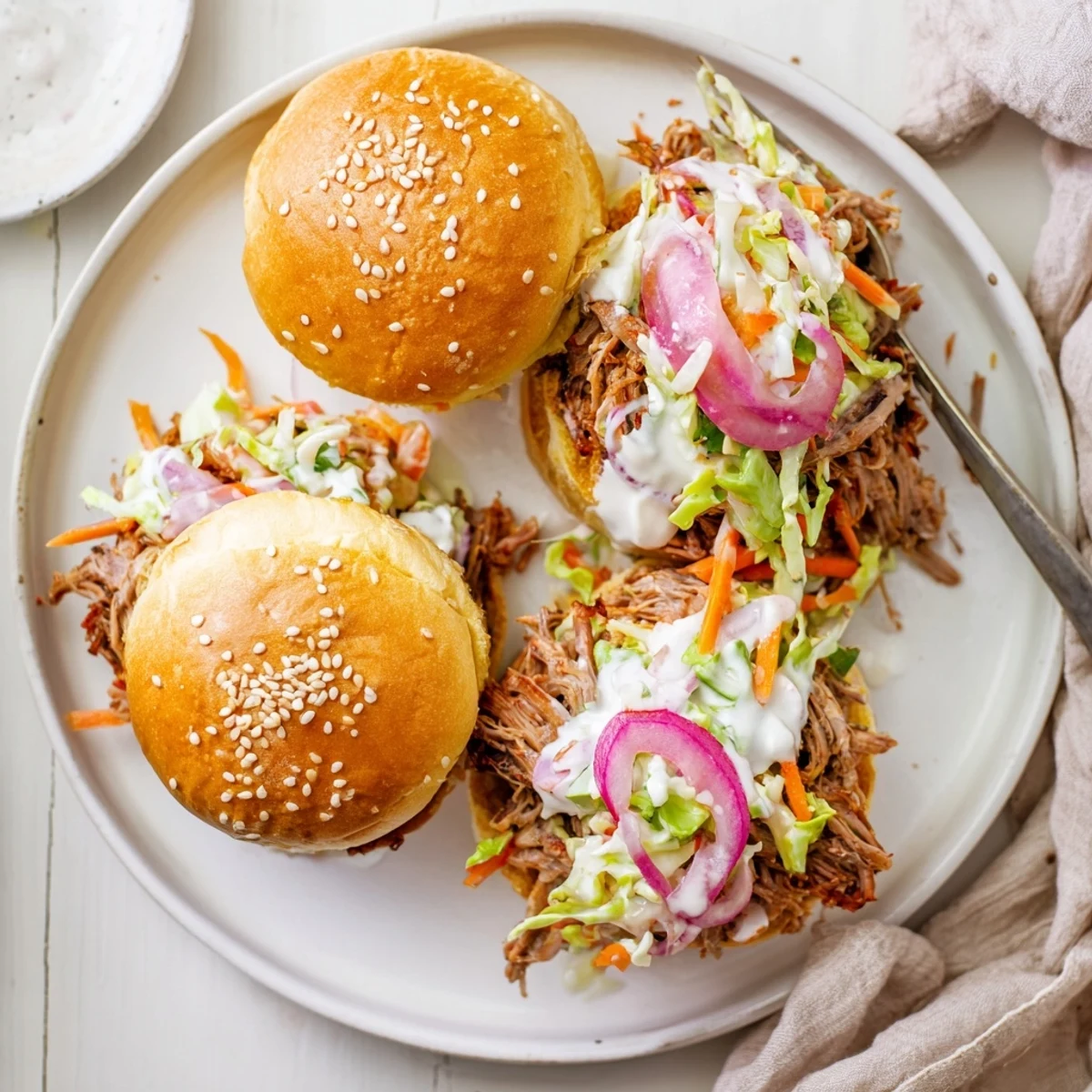 Alabama white sauce pulled lamb sliders piled on soft buns with crisp slaw