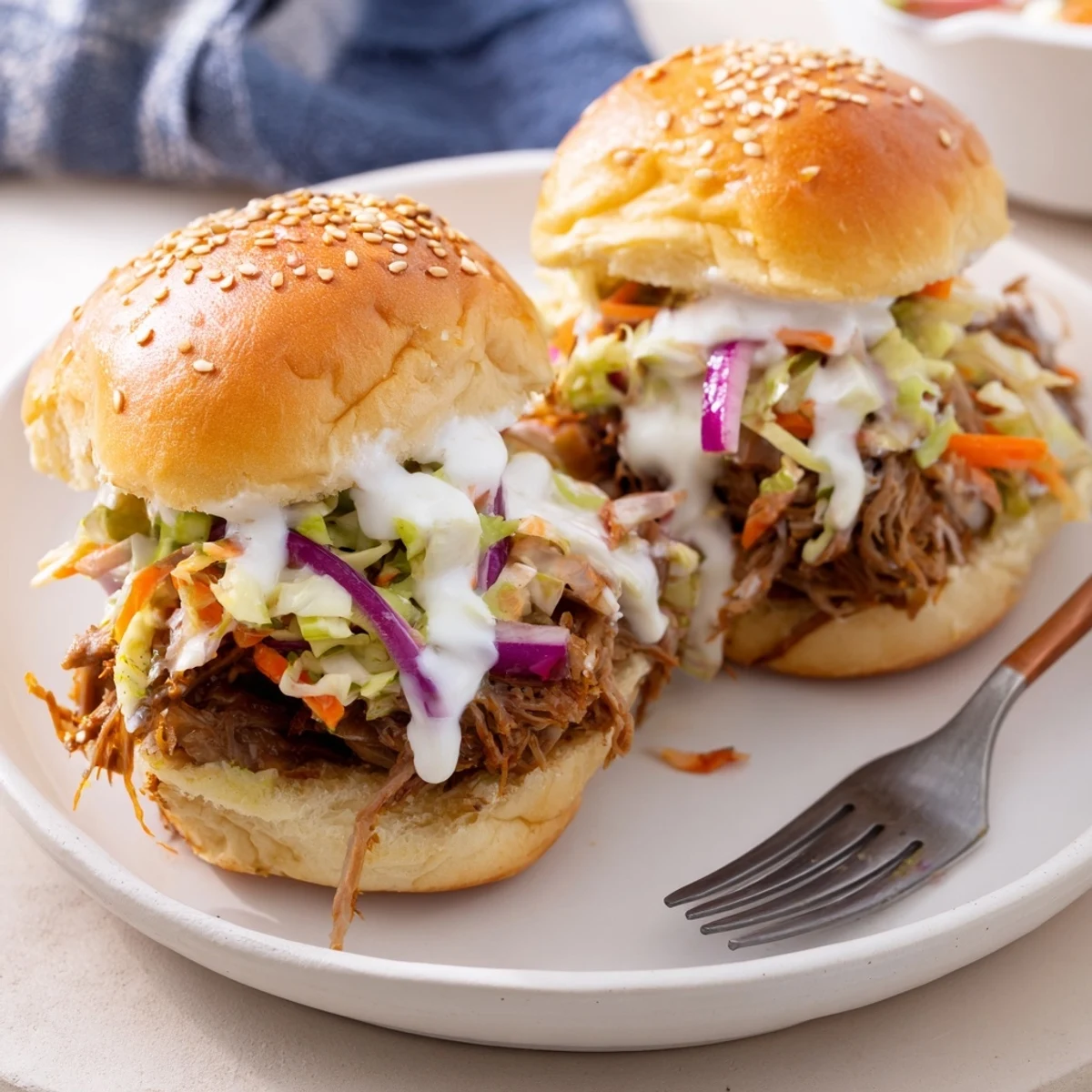 Tangy Alabama white sauce pulled lamb sliders topped with crunchy cabbage and pickled onions