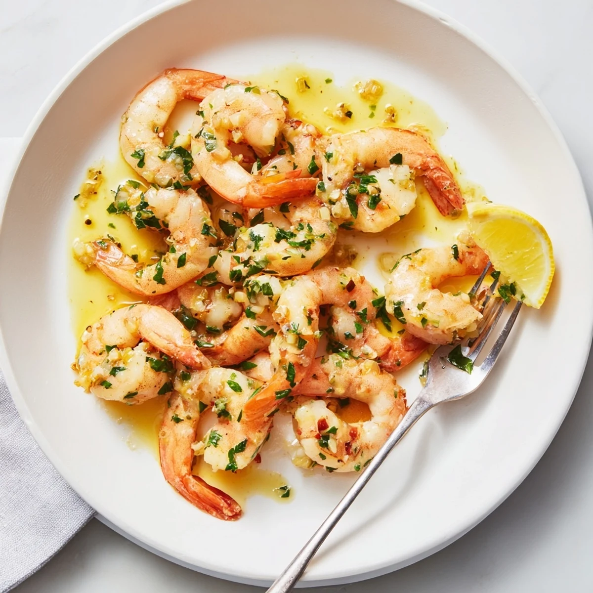 Golden buttered shrimp glistening in garlicky sauce with fresh parsley and lemon wedges