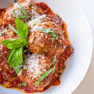 Hearty ricotta and mushroom meatballs simmer in a savory tomato sauce, served over al dente spaghetti for dinner.