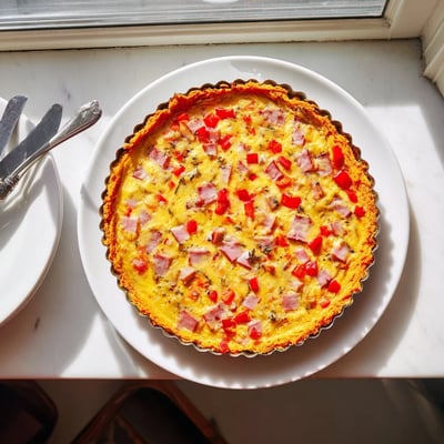 Close-up of a vibrant Red Capsicum and Ham Quiche with Sweet Potato Crust, featuring diced red peppers and smoked ham in a gluten-free slice.